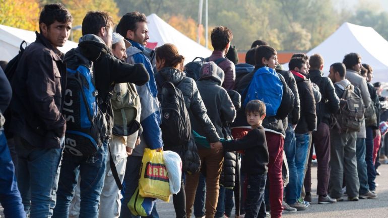 Refugees wait at a inspection station near the Austrian-German border near to Passau, Germany, 30 تشرين الأول 2015. An escalating row in Chancellor Angela Merkel's government over mass arrivals of migrants from war zones provoked a rebuke on 30 تشرين الأول 2015 from German deputy Chancellor Sigmar Gabriel, leader of Germany's Social Democratic Party (SPD). Merkel's أيلول 5 decision to open Germany's borders and absorb migrants has won global praise but local recrimination. The ruling party of southern Bavaria state, the Christian Social Union (CSU), is pressing Merkel's Christian Democrats (CDU) to limit new arrivals. A key bone of contention is a CSU demand for "transit zones" at the Austrian border, analogous to the sealed-off sections of airports where transferring passengers change plane without going through a country's immigration control.
