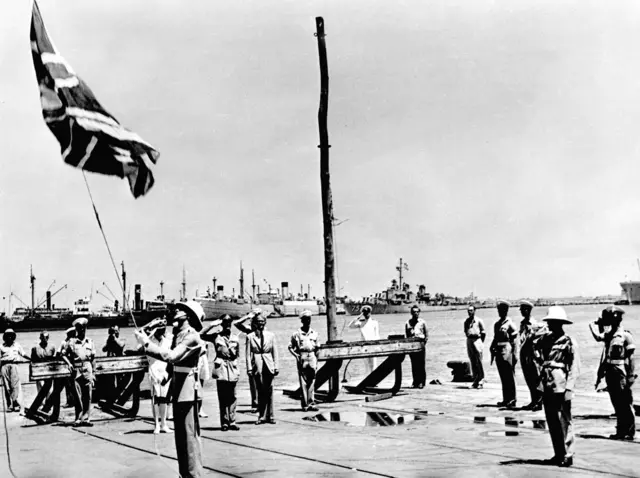 أحد أفراد الجيش البريطاني ينزل علم بلاده للمرة الأخيرة في 30 حزيران/حزيران 1948 في ميناء حيفا