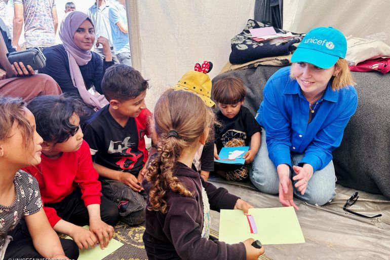 UNICEF Spokesperson Tess Ingram, right, speaks with children who were participating in psychosocial activities with UNICEF partner Tamer, at the Tel al Soltan Stadium Camp on 3 نيسان, 2024, in Rafah, Southern Gaza.