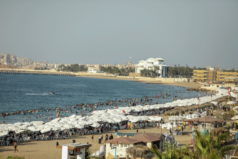 ALEXANDRIA, EGYPT - AUGUST 20: People cool off at the beach as residents and tourists flock to the city’s coasts and parks to escape the heat on آب 20, 2025 in Alexandria, Egypt.