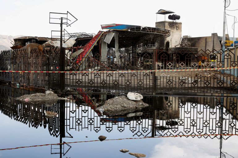 A destroyed fuel station is reflected in a pool of water one day after Israeli airstrikes hit the station in Sanaa, Yemen, آب 25, 2025. REUTERS/Stringer