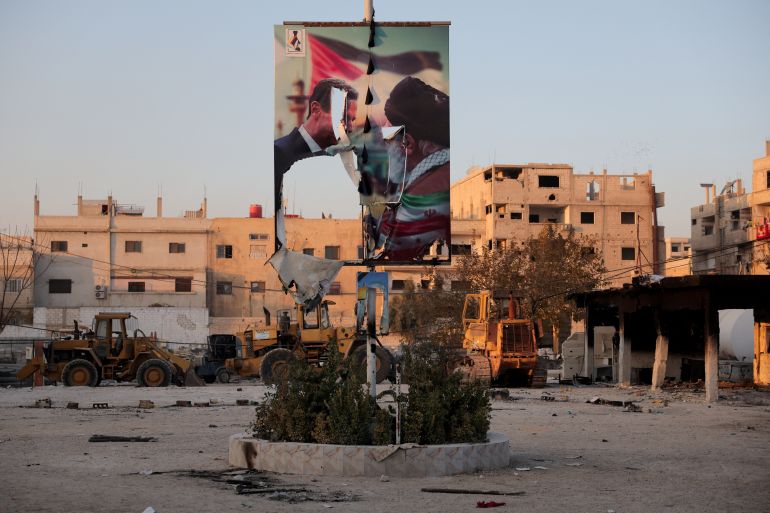 A torn poster showing former Syrian President Bashar al-Assad meeting with Iran's Supreme Leader Ayatollah Ali Khamenei, in the Sayyida Zaynab district in Damascus, Syria, كانون الأول 14, 2024. REUTERS/Amr Alfiky