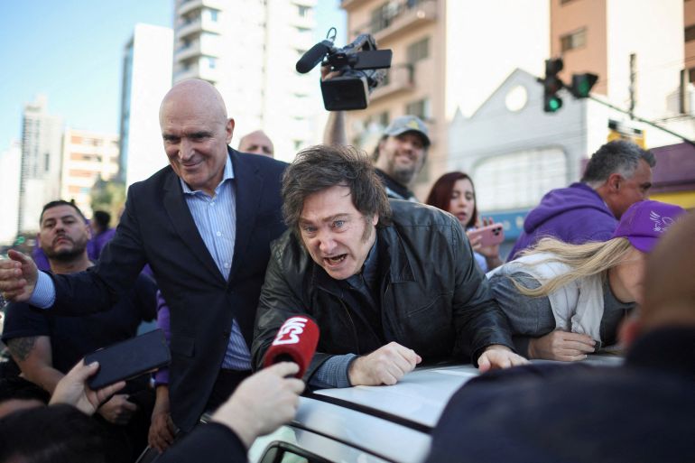 Argentina's President Javier Milei speaks to the media, while standing on a vehicle with lawmaker Jose Luis Espert to attend a La Libertad Avanza party rally ahead of legislative elections in the province of Buenos Aires, in Lomas de Zamora on the outskirts of Buenos Aires, Argentina, آب 27, 2025. REUTERS/Agustin Marcarian