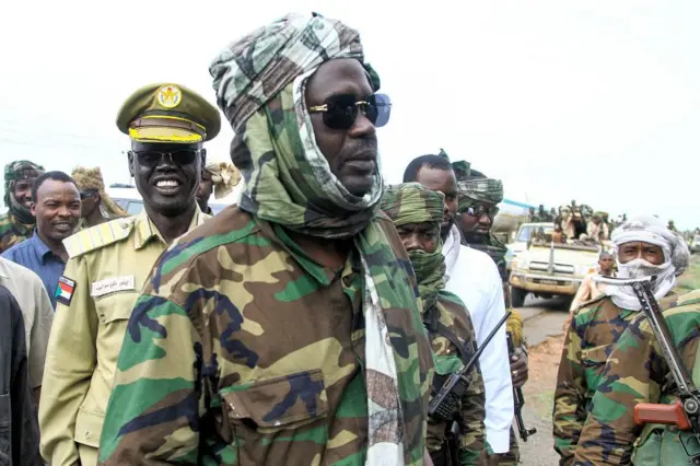 مني مناوي (في الوسط)، حاكم إقليم دارفور في السودان، يُستقبل من قبل السكان المحليين خلال توقفه في مدينة القضارف شرقي البلاد، أثناء توجهه إلى بورتسودان في 30 آب/آب 2023.