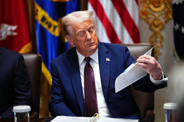 epa12324355 United States President Donald J Trump looks at a chart as he chairs a Cabinet meeting in the Cabinet Room of the White House in Washington, DC, USA, 26 آب 2025. EPA/AARON SCHWARTZ / POOL