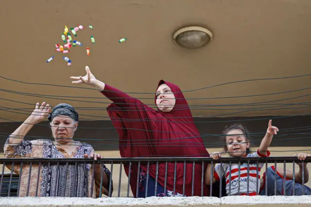سيدة تلقي الحلوى خلال مرور موكب الاحتفال بالمولد النبوي في القاهرة 27 أيلول/أيلول 2023