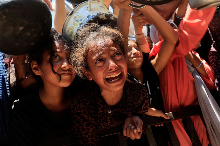 Palestinians wait to receive food from a charity kitchen, amid a hunger crisis, in Khan Younis, southern Gaza Strip, آب 4, 2025. REUTERS/Hatem Khaled TPX IMAGES OF THE DAY