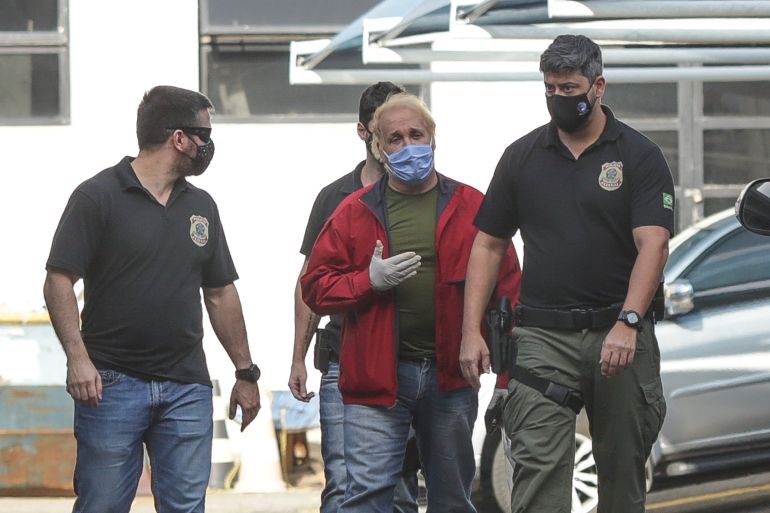 RIO DE JANEIRO, BRAZIL - JUNE 25: A person (C) is taken into custody by the federal police during operation Fiat Lux at federal police headquarters amidst the coronavirus (COVID-19) pandemic on حزيران 25, 2020 in Rio de Janeiro, Brazil. This morning the Federal Police began Operation Fiat Lux, an arm of Operation Lava Jato that investigates fraud at Eletronuclear. There are 12 temporary arrest warrants and 17 search and seizure warrants, among them is the former Minister of Mines and Energy during the Lula government, Silas Rondeau. Another target of the operation is the businessman Jose Eduardo Telles Villas, accused of money laundering, foreign exchange evasion, corruption and criminal organization. (Photo by Andre Coelho/Getty Images)