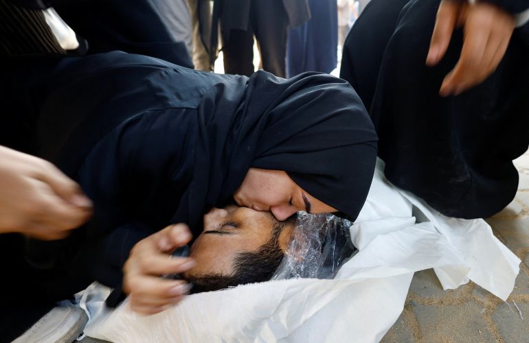 SENSITIVE MATERIAL. THIS IMAGE MAY OFFEND OR DISTURB A mourner reacts next to a body during the funeral of Palestinians who were killed by Israeli fire while trying to receive aid and another killed in a strike on Friday, according to medics, at Al-Shifa Hospital in Gaza City, آب 30, 2025. REUTERS/Mahmoud Issa